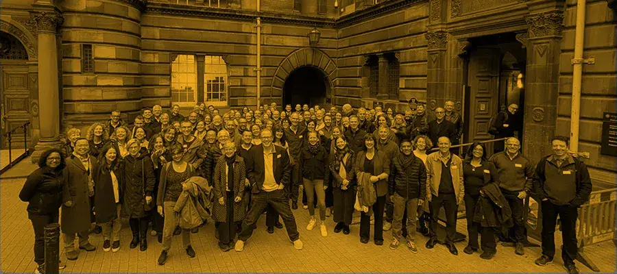 Group photo of alumni event participants wiith an orange overlay